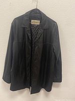 Front view of the men's black leather jacket showing its collar, button closure, and overall shape on a hanger.
