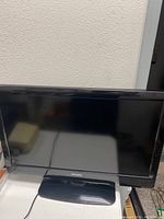 Front view of a Philips 32 inch LCD TV with black bezel and stand, powered off.