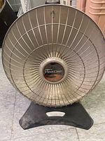 Front view of the vintage Presto HeatDish electric heater showing metal mesh grill and central branding.