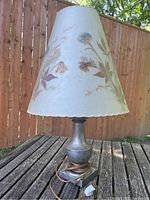 Overall view of lamp showing pewter base, cord and conical floral shade