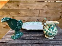 Overview of the three-piece dish set including an oval platter and two jugs on a wooden surface with natural wood backdrop.