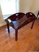 Photo of the expandable wood coffee table showing side view with hinged tray sides in raised position and cut-out handles.