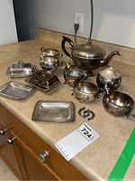 Full set displayed including teapot, cream and sugar bowls, butter dishes, and trays on kitchen counter