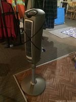 Full view of the Lasko oscillating tower fan showing its moderate height and wide base on a patterned floor surface.