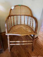Front view of vintage wooden chair with cane back and cane seat on hardwood floor.