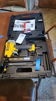DeWalt DWFP12231 power nailer and Porter Cable nails in molded carrying case with instruction manual visible.