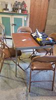 Card table and four chairs set displayed in a room showing condition and overall look.