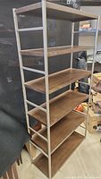 Front and side views of a used brown metal shelf unit with six wooden shelves.