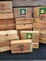 Stack of wooden cigar boxes, some branded Mella and Burger.