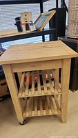 Side view of Ikea Bekvam kitchen trolley showing wooden slatted shelves and caster wheels
