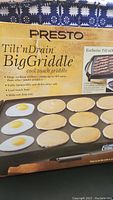 Photo of the front of the box showing the product name, features like large cooking surface, cool touch handles, and slide-out drip tray