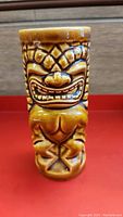 Full front view of the vintage ceramic tiki mug showing the carved face and body with brown glaze.