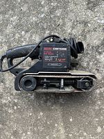 Side view of SEARS CRAFTSMAN label showing specifications 3/4 HP, 21 inch sanding belt, and power cord.