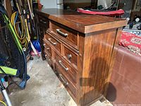Front and side view of the solid wood dresser showing drawer arrangement and wood finish.