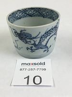 Front view showing dragon chasing pearl motif on the cup in blue underglaze on white porcelain.