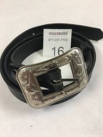 Belt coiled with Sputnik buckle facing up, showcasing buckle and belt design.
