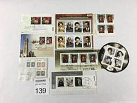Overview of all stamps and souvenir sheets in the lot. Various Canadian famous people themed stamps and sheets laid out flat on white background.