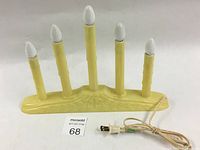 Full view of yellow vintage style electric Christmas candle holder with six candle bulbs and attached power cord