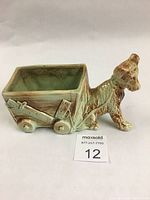 Side view of vintage McCoy Pottery dog and cart planter with visible details of glaze and shape.
