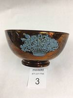 Front view of lusterware bowl showing one blue basket flower applique with full details, copper luster glaze clean and intact on surface.