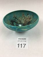 Front angled view of turquoise ceramic bowl showing varying glaze and pattern.