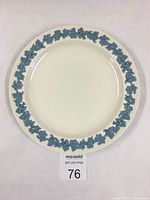 Full view of cream-colored 10-inch Wedgwood plate with blue raised grapevine pattern around the rim.