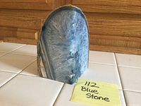 Front view of the blue stone showing polished crystalline interior with radial blue and white crystal formations.