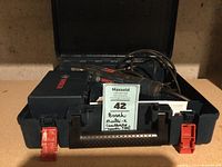 Open carrying case showing the Bosch Multi-X power tool, accessory box, and power cord inside.