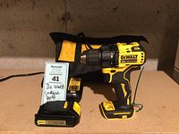 DeWalt 20V cordless drill with charger, two batteries, and carrying case on a table.