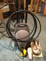 Full view of the BCP pressure washer with hose coiled on unit plus three different brushes displayed beside it.