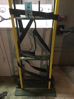 Front view of the Harper hand truck showing yellow handles and attached black nylon straps.