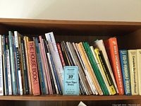 Shelf of assorted home improvement and repair books showing various titles and colorful spines.