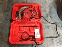 Milwaukee 7-1/4 inch Tilt-Lok circular saw inside its red hard plastic carrying case with power cord coiled inside.