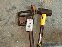 Full view of the wood splitting set: Fiskars axe, splitting wedge, and sledgehammer on carpet