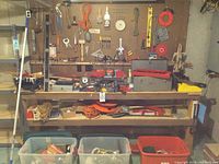 Workbench and pegboard overview with toolcases and plastic bins