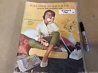 Front cover photo showing a woman sitting cross-legged, holding a telephone with a yellow background.