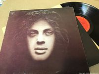 Billy Joel Piano Man vinyl LP cover front with vinyl record partially removed showing red Columbia label.