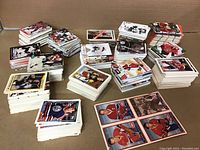 Numerous stacks of hockey cards arranged on a flat surface, showing a wide variety of players and card designs visible on the top cards in each stack.
