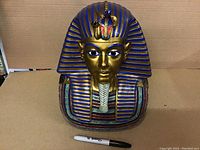 Front view of the large King Tut ceramic bust showing colors and facial details with a Sharpie placed below for size reference.