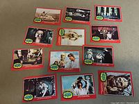 Overview of eleven Star Wars 1977 trading cards with red borders and yellow Star Wars logo bursts featuring various scenes and characters.