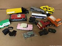 Overview of all 14 diecast vehicles of varying models and colors on a cardboard surface.