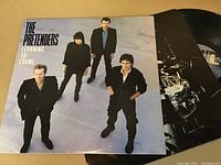 Photo of The Pretenders LP record cover showing four band members and the album title, with the vinyl partially visible beside it.