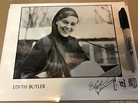 Photo showing the Edith Butler signed 8x10 black and white publicity photo with signature visible on bottom right corner, alongside a Sharpie for size reference.