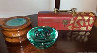Photo showing wooden jewelry box with brass hardware, turquoise glass bowl, and round wooden agate coaster holder with lid