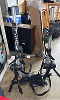 Photo shows the full bike rack with the dual upright holders, adjustable clamps, and black straps lying on the floor among other items.