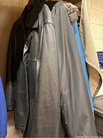 Photo of four winter jackets hanging on a rack, showing material and colors