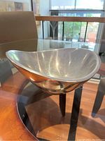 Front angled view of the Nambe metal bowl showing smooth curved edges and polished surface reflecting light.