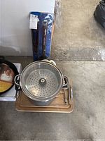Stock pot with strainer and package of LA Dodgers BBQ utensils behind