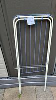 Laundry rack folded flat showing the metal frame and blue lines hanging vertically