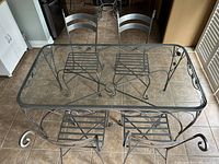 Top-down view of the rectangular glass top dining table with grey powder coated iron frame and 4 matching chairs arranged around it showing condition and design details.
